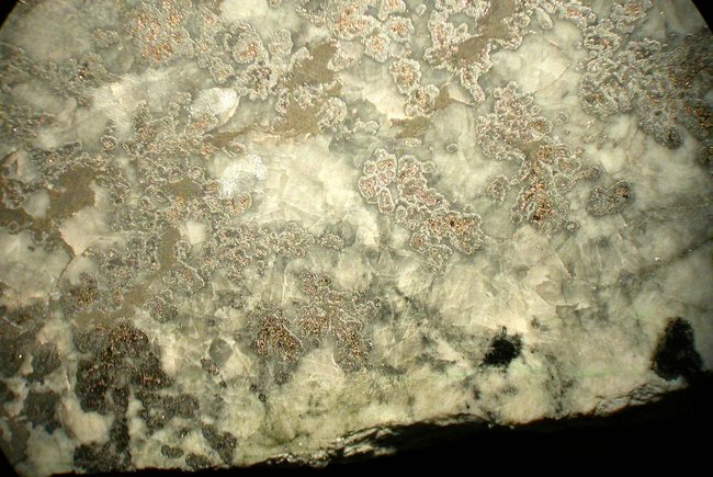 Eindeutig drei verschiedene metallisch glänzende Einschlüsse im Calcit