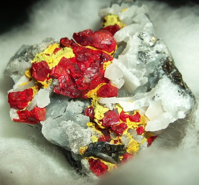 Feuerroter Realgar, gelber Auripigment, weisse Baryt Tafeln und weisser Chalcedon